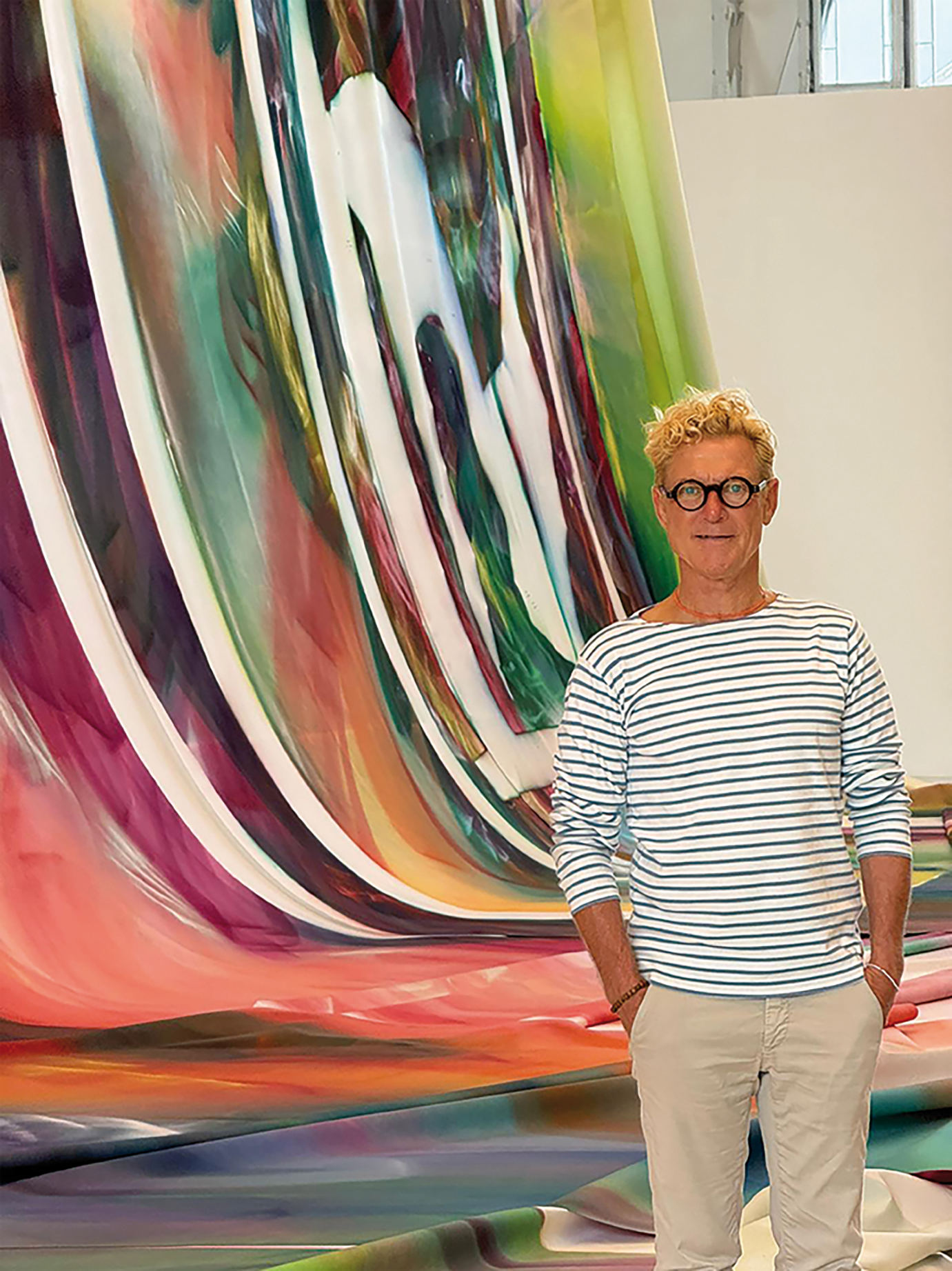 Markus Böhler standing in his studio before a large gradient painting